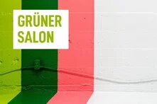 Logo des Grünen Salons vor einer gestreift angemalten Wand