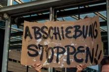 Hände halten Plakat in die Höhe mit der Auschrift: Abschiebung stoppen!