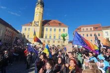 Menschen in Bautzen bei einer Kundgebung mit Regenbogen- und Europafahnen in 2024