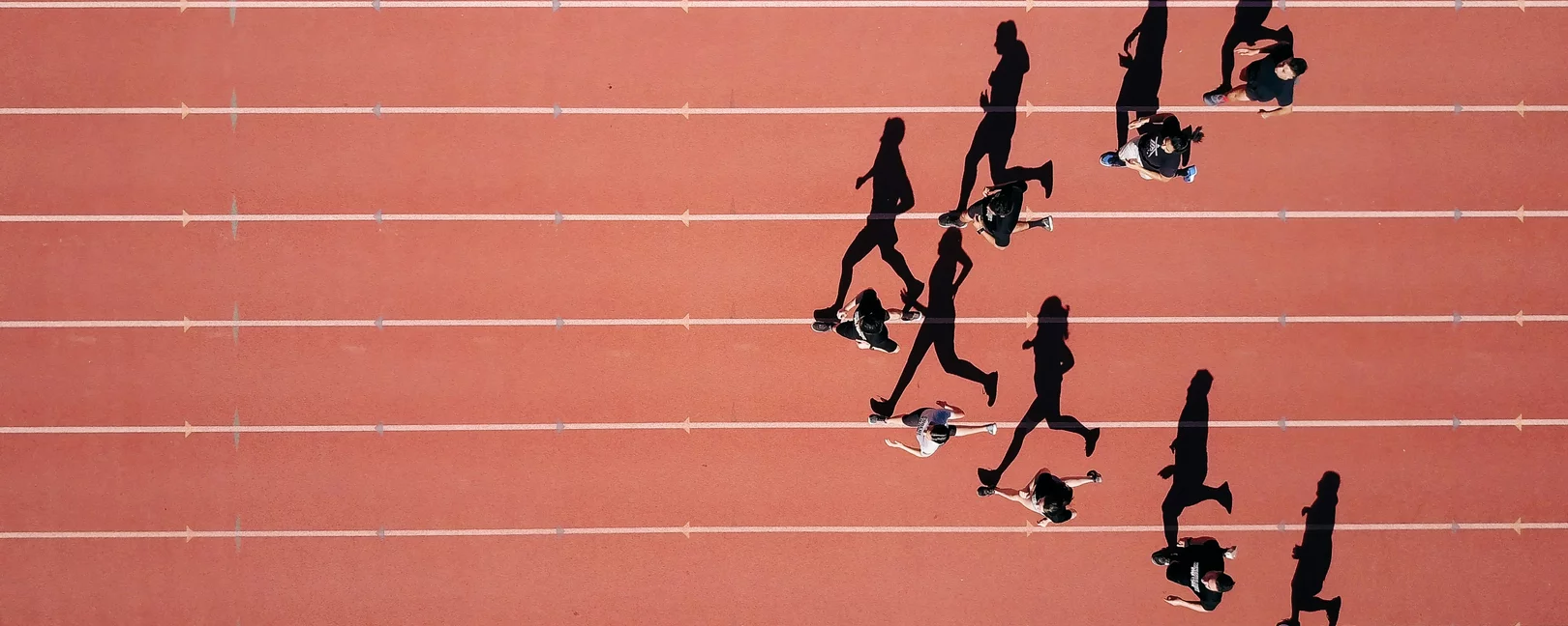 Läufer*innen auf einem Sportplatz